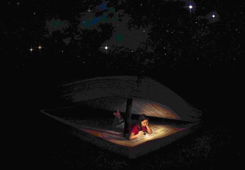 Girl in tent reading the Bible with a flashligt